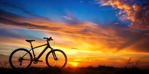 Obraz premium Silhouette of a bicycle or ebike against a vibrant sunset background, silhouette, bicycle, ebike, sunset, colorful, sky