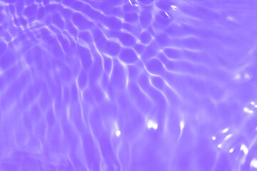 Purple water bubbles on the surface ripples. Defocus blurred transparent pink colored clear calm water surface texture with splash and bubbles. Water waves with shining pattern texture background