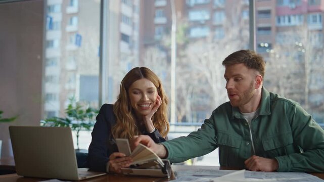 Designer proposing material samples to man client in office workplace closeup.