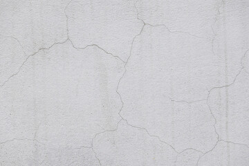 Cracks in walls after plastering and painting. White painted plaster with thin cracks in building...