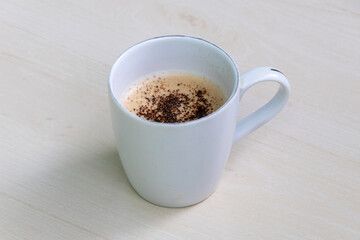 A cup of hot coffee on wooden surface.