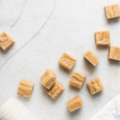 Overhead view of peanut butter fudge on a white marble tray, top view of soft caramel fudge squares