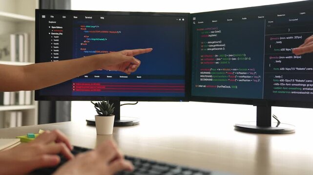 Slow motion back end software developer engineer for computer programming working together on debugging writing computing code, solving complex algorithms display on monitor in office. Burgeoning