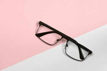 Reading glasses isolated on grey and pink background. Fashion spectacles for man and woman