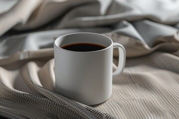 A cup of coffee sits on top of a bed