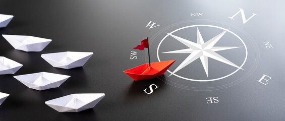 Red Paper Boat On Compass Leading A Fleet Of Small White Boats. Business Leadership Concept.