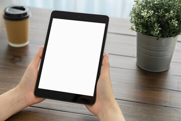 Mock up of woman hand holding digital tablet and touching blank screen.