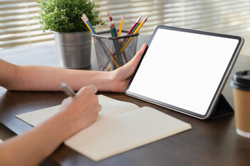 Mock up of woman hand holding digital tablet and touching blank screen.