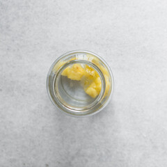 Overhead view of pineapple cheong in a glass jar on a white background, top view of korean pineapple cheong in a transparent jar, pineapple in sugar syrup, process of making pineapple cheong