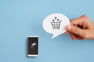 User-generated content concept.UGC, Online marketing. Customer create content on social media. Hand hold real white speech bubble paper with shopping cart icon and mobile phone with UGC icon on screen