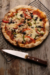 Pizza is a savory dish from Italy, a type of round, flat dough, which is baked in the oven and usually covered in tomato sauce and cheese with other additional food ingredients.