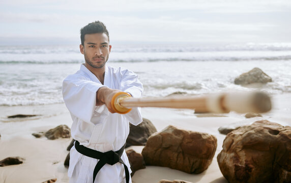 Karate, beach and man with katana for training, practice and learning aikido, taekwondo and jiujitsu. Sports, nature and person with bokken by ocean for fitness, exercise and workout for martial arts