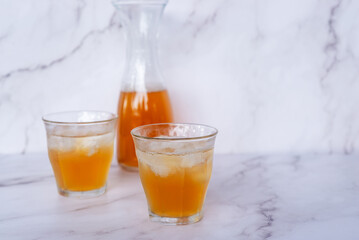 Two glass of homemade Kombucha on the marble table, healthy fermented tea beverages.