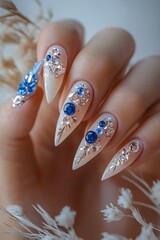 A woman's hand with a white manicure with blue and white flowers on it