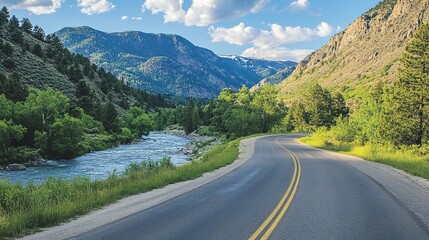 Fototapeta premium Winding Road Through Mountain Valley with River and Lush Vegetation