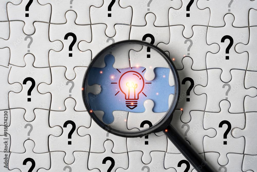 Aufkleber glowing light bulb inside magnifier glass among question mark on jigsaw puzzle for focus and concent