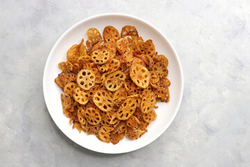 Crispy lotus stem chips, perfectly spiced and golden-brown, offer a delightful crunch and unique flavor. Ideal for snacking or as a gourmet appetizer. kurkuri Kamal kakdi. copy space.