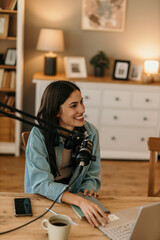 Female content creator using a laptop and mic and announcing new episode of her podcast