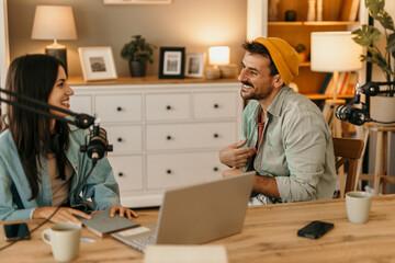 Two people in the podcast studio talking and recording during the day
