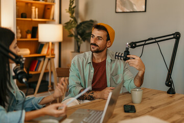 Couple enjoying a lively conversation while recording a podcast in their living room