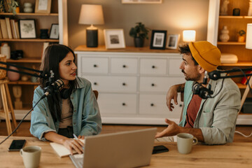 Man and woman podcasting with professional equipment in a cozy living room