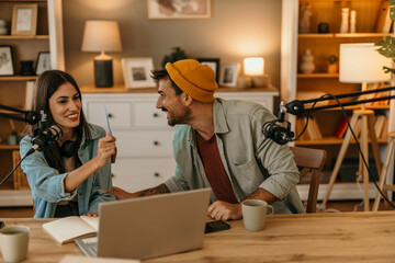 Man and woman podcasting with professional equipment in a cozy living room