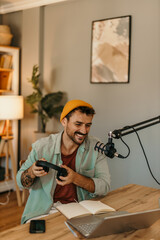 Man speaking into a microphone, creating content in a relaxed setting, putting headphones on