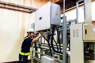 Electrical engineer working in control room. Electrical engineer man checking Power Distribution Cabinet in the control room