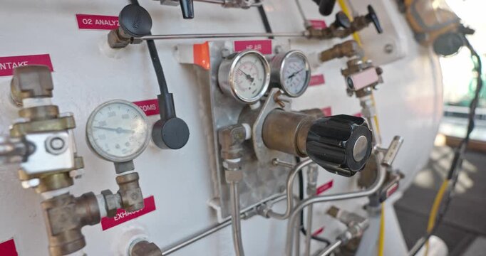 Side view of hyperbaric chamber with valves and pipes closeup