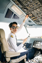 Asian Confident male pilot in uniform leaning at the passenger seat while standing inside of the airplane flight © Nuttapong punna