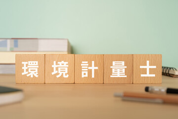 環境計量士と書かれたブロックが置かれたデスク
