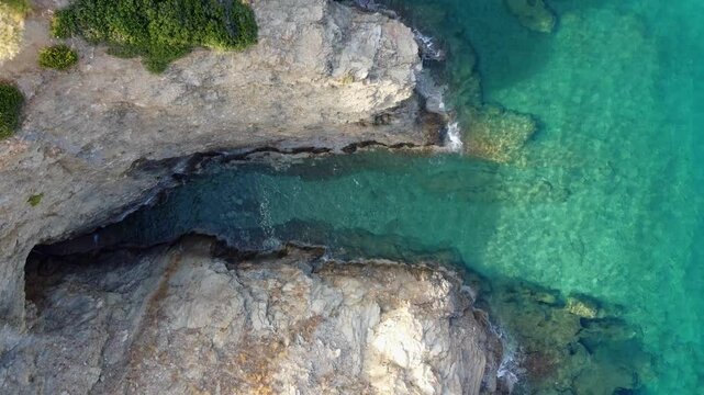 Drone flies in bird's eye view over the sea in evita bay Bali on Crete in Greece sea is blue and clear a beautiful bay with beach