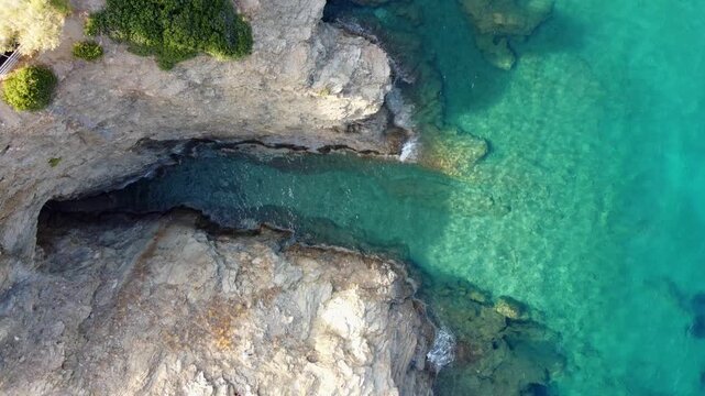 Drone flies rotating in bird's eye view over the sea in evita bay Bali on Crete in Greece sea is blue and clear a beautiful bay with beach