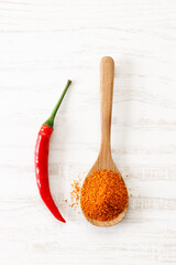 red chilie and ground chilies on white wooden table.