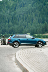 Fototapeta premium Side view of SUV with bikes driving near Alps