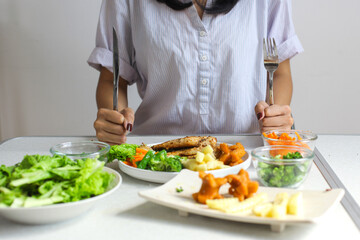 Female Hands Holding Fork And Knife While Eating Chicken Steak With Salad