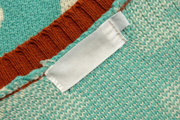 White blank laundry care clothes label on blue shirt fabric background