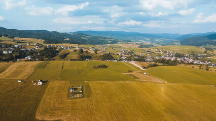 Obraz premium Tranquil countryside with vibrant fields and mountain range in distance