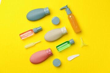 Colorful Travel-Sized Bottles and Containers on a Yellow Background