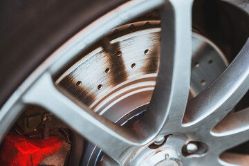 Closeup of drilled performance disc brake rotor on car