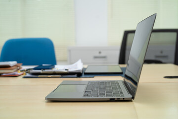 An executive work desk sits in an office, meticulously arranged with documents and office supplies....