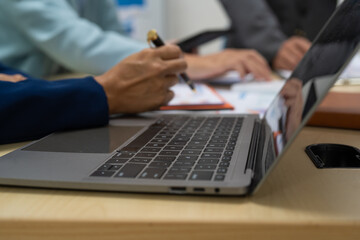 A businessperson  financial analyst during a corporate meeting. review a graph document, discussing financial data and strategies to ensure successful outcomes effective teamwork achieving corporate