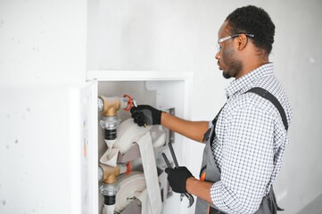 The worker installs or inspects Fire extinguisher and fire hose reel in building corridor