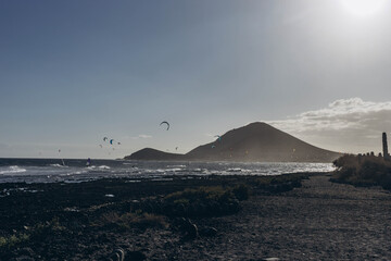 Men professional surfer standing on the sandy beach with his kite and board. Windsurfing, Extreme Sport
