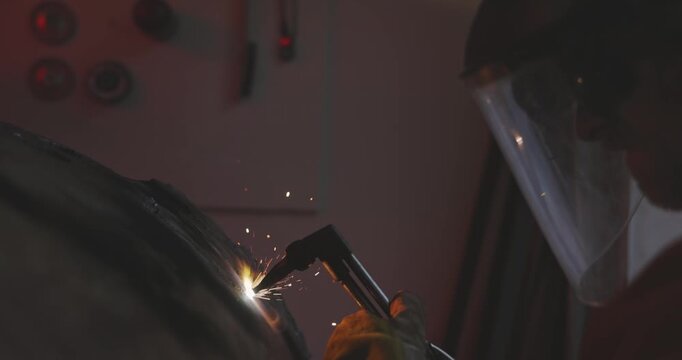 Worker in protective gear using oxy-fuel torch