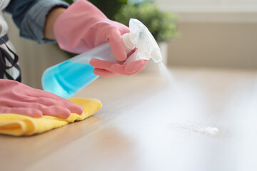 Close-up hand of maid cleaning table during household job.