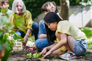 Teacher and young students during outdoor sustainable education, lesson in forest school. Planting...