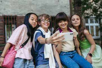 Four friends taking selfie outdoor.