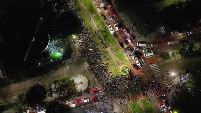 Night aerial: Women's Day marchers arrive at courthouse on city street