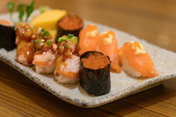 Different types of delicious sushi on plate.